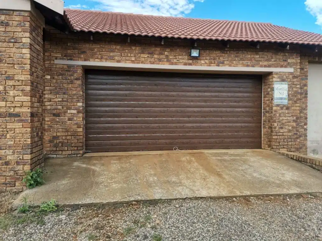 Double wood look garage door installed outside view